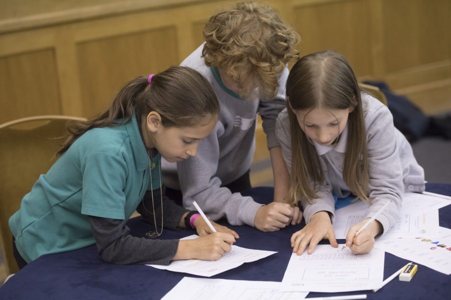 A group of primary school pupils take part in a codebreaking activity.