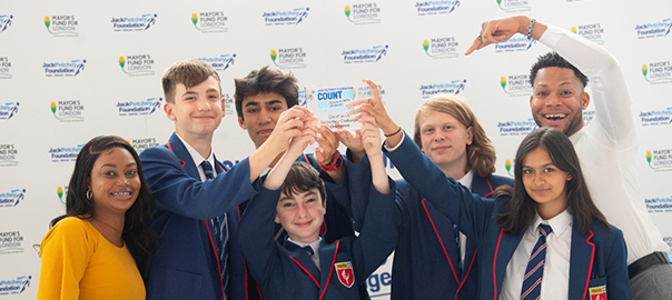 A photo of Harris Academy Beckenham's winning Count on Us team holding the Champions trophy aloft at London's City Hall.